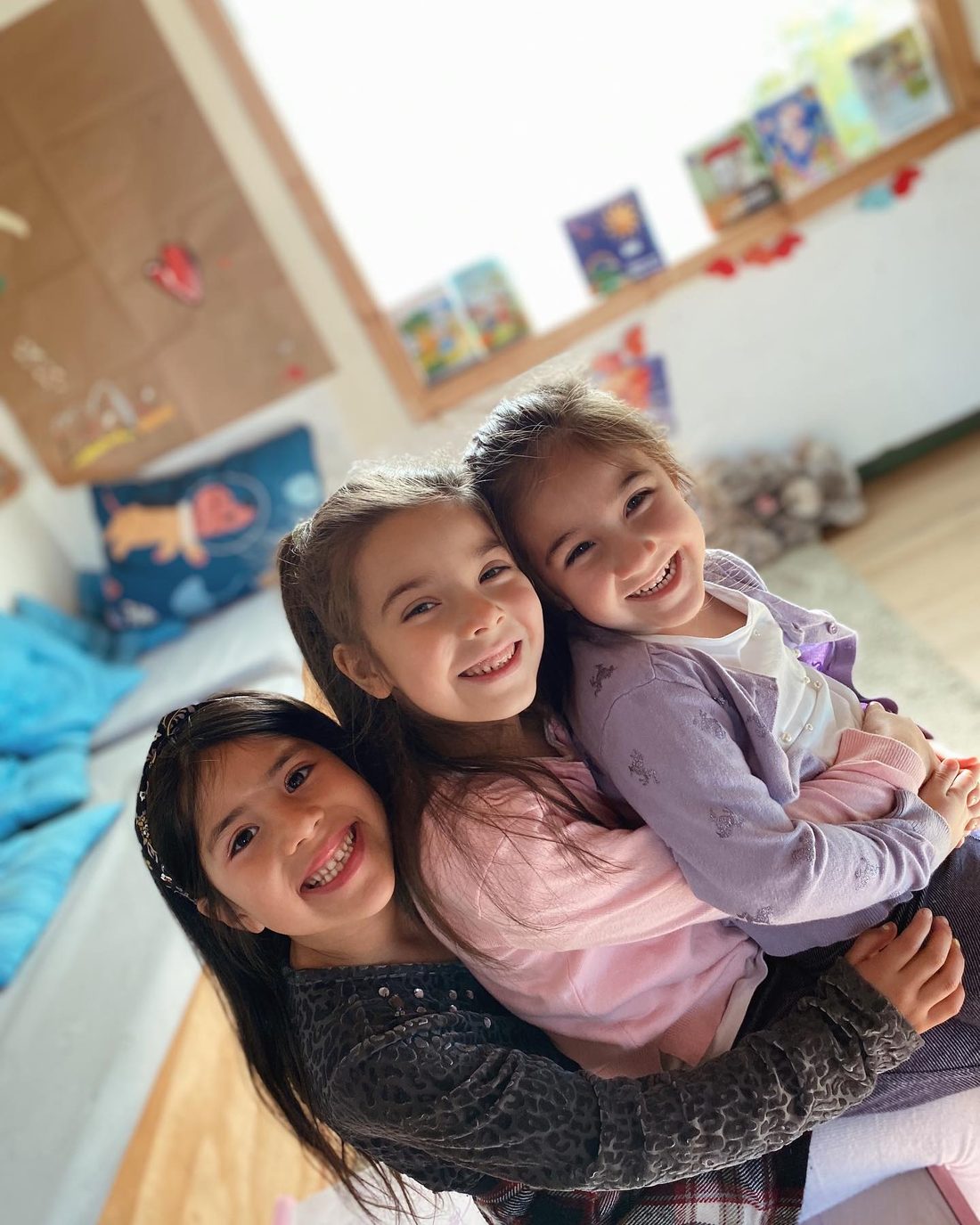 Educadora abrazando a estudiantes en el colegio